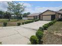 Well-maintained home with a long driveway, attached garage, and landscaped front yard at 516 Marion Oaks Dr, Ocala, FL 34473