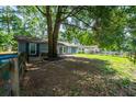 Cozy single-story home with blue shutters situated on a spacious lot with mature trees and partial fencing at 5737 Nw 65Th Pl, Ocala, FL 34482