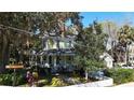 Charming yellow two-story home with a welcoming front porch under a beautiful tree at 743 E Fort King St, Ocala, FL 34471