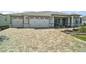 Paver driveway leading to a lovely single-story home with a spacious two-car garage at 8457 Sw 97Th Cir, Ocala, FL 34481