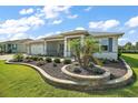 Inviting single-story home with a curved stone garden feature and lush green lawn at 8457 Sw 97Th Cir, Ocala, FL 34481