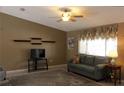 Cozy living room featuring neutral tones, plush seating, and a ceiling fan for added comfort at 10843 Sw 91St Ter, Ocala, FL 34481