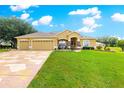 Charming single-story home featuring a three-car garage and manicured lawn with beautiful landscaping and plenty of curb appeal at 13885 Del Webb Blvd, Summerfield, FL 34491