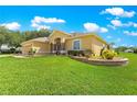 Well maintained yard featuring decorative stone retaining wall and meticulously manicured landscaping surrounding the home at 13885 Del Webb Blvd, Summerfield, FL 34491