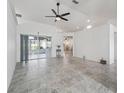 Bright living room featuring tile floors, a modern ceiling fan, and sliding glass doors leading to the lanai at 17755 Se 117Th Cir, Summerfield, FL 34491