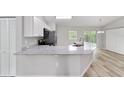Open-concept kitchen boasts modern white cabinets, sleek countertops, and stainless steel appliances, perfect for culinary enthusiasts at 23163 Nw Shamrock Ave, Dunnellon, FL 34431