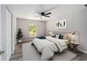 The light and airy main bedroom features stylish decor, a ceiling fan and view of surrounding woods at 23163 Nw Shamrock Ave, Dunnellon, FL 34431