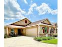 Charming single-story home featuring a well-manicured lawn and colorful landscaping with red shutters, and a red roof at 3023 Charlevoix St, The Villages, FL 32163