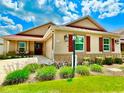 Charming single-story home featuring a well-manicured lawn and colorful landscaping with red shutters, and a red roof at 3023 Charlevoix St, The Villages, FL 32163