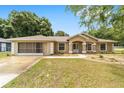 Charming single-story home featuring a well-maintained lawn, screened garage and an inviting entrance at 4886 Nw 30Th Pl, Ocala, FL 34482