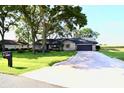 Inviting brick home with a well-manicured lawn, mature trees, and a long driveway at 5351 Sw 80Th Pl, Ocala, FL 34476