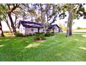 Brick home with a lush front yard and mature trees creating a tranquil setting at 5351 Sw 80Th Pl, Ocala, FL 34476