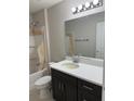 Bathroom featuring a shower with tan covering and a dark vanity with a white countertop at 5359 Nw 55Th Pl, Ocala, FL 34482