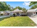 Well-maintained single-story home with a front lawn, an American flag, an attached garage, and mature landscaping at 8712 Sw 92Nd St # C, Ocala, FL 34481