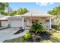Charming single-story home with a brick facade, attached garage, and a cozy front porch adorned with an American flag at 8712 Sw 92Nd St # C, Ocala, FL 34481