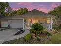 Charming single-story home with a brick facade, attached garage, and a cozy front porch adorned with an American flag at 8712 Sw 92Nd St # C, Ocala, FL 34481