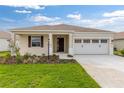Inviting single-story home featuring a well-kept lawn, and a convenient two-car garage at 8783 Sw 69Th Place Rd, Ocala, FL 34481