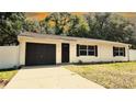Inviting single-story house featuring a convenient attached garage and a freshly sealed driveway at 9 Pine Radial Ct, Ocala, FL 34472