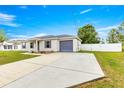 This house has a paved driveway, a grey roof and shutters, and a well-maintained lawn at 97 Dogwood Cir, Ocala, FL 34472