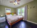 Spacious bedroom featuring a ceiling fan, hardwood floors, and natural light from the windows at 116 Nw 17Th Pl, Ocala, FL 34475