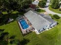 Aerial view of the property showcasing a screened pool, green lawn, and the home's layout at 11651 Sw 77Th Cir, Ocala, FL 34476