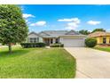 Charming single-Gathering home with manicured lawn, mature trees, and an attached two car garage at 1402 Arredondo Dr, The Villages, FL 32162
