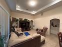 Spacious living room featuring tile flooring, a tray ceiling, and comfortable seating at 15011 Sw 61St Court Rd, Ocala, FL 34473