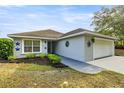Charming single-story home featuring mature landscaping, flower beds, and an attached two-car garage at 15465 Se 113Th Street Rd, Ocklawaha, FL 32179