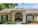 Inviting front entrance with a decorative archway, black door, and manicured landscaping at 1617 Se 29Th Ter, Ocala, FL 34471