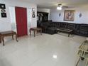 Bright living room with tile floor, comfy leather seating, and red front door at 1737 Griffin Ave, Lady Lake, FL 32159