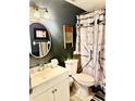 Charming bathroom featuring a rustic shower curtain, oval mirror and ample lighting at 3106 Silver Palm Dr, Edgewater, FL 32141