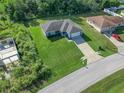 Aerial view of a well-kept home featuring a spacious lawn and quiet neighborhood street at 32 Pine Course Loop, Ocala, FL 34472