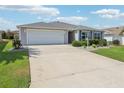 Single-story home with a two-car garage and a well-maintained concrete driveway at 3500 Countryside Path, The Villages, FL 32163
