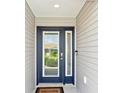 Stylish blue front door with glass panels and a digital lock system at 3500 Countryside Path, The Villages, FL 32163