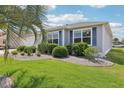 Landscaped front yard with manicured lawn, shrubbery, and decorative rock border at 3500 Countryside Path, The Villages, FL 32163