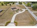 Expansive home featuring a screened pool, a long driveway and mature landscaping at 4725 County Road 121D, Wildwood, FL 34785