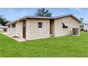 The back exterior shows a well-kept lawn and siding, with an access door at 6468 Sw 107Th Pl, Ocala, FL 34476