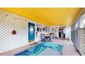 Inviting screened patio with bright yellow ceiling, colorful decor, and comfortable seating area at 6468 Sw 107Th Pl, Ocala, FL 34476