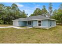 A view of the side and front of a delightful single-story home with an attached garage and spacious yard at 7299 Sw 202 Ct, Dunnellon, FL 34431