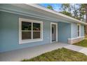 Inviting front porch and entryway, featuring a large window that fills the home with natural light at 7299 Sw 202 Ct, Dunnellon, FL 34431