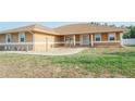 Charming home's front yard features lush grass, a small gravel area, and rocking chairs at 7475 Se 105Th Pl, Belleview, FL 34420