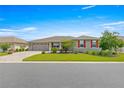 Charming single-story home with a well-manicured lawn, red shutters, and a brick-paved driveway at 8111 Sw 95Th Ct, Ocala, FL 34481