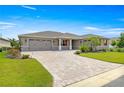 Charming single-story home with a well-manicured lawn, red shutters, and a brick-paved driveway at 8111 Sw 95Th Ct, Ocala, FL 34481