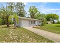 Charming single-story home featuring a one car garage and a well-maintained front yard with mature trees at 8449 Sw 105Th Pl, Ocala, FL 34481