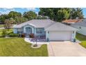 Well-maintained single-story home with light blue exterior and an attached two-car garage at 8722 Sw 60Th Cir, Ocala, FL 34476