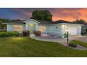 Charming single-story home at sunset featuring a well-manicured lawn and light blue exterior at 8722 Sw 60Th Cir, Ocala, FL 34476