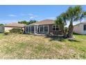 Backyard with a screened-in patio, lawn, and palm tree at 9649 Sw 90Th St, Ocala, FL 34481