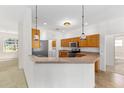 Kitchen featuring wood cabinets, stainless steel appliances, breakfast bar and hanging lights at 9649 Sw 90Th St, Ocala, FL 34481
