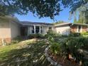 Inviting front entrance with a stone walkway and vibrant garden at 9850 Sw 191St Ave, Dunnellon, FL 34432