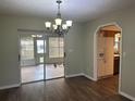 Bright dining room with sliding glass doors, chandelier, and access to the kitchen at 10739 Se 44Th Ter, Belleview, FL 34420